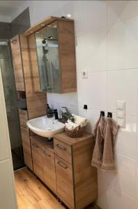 ein Bad mit einem Waschbecken und einem Spiegel in der Unterkunft Ferienwohnung Ostfriesenherz Emden in Emden