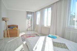 a white bedroom with a bed and a window at Ahmet teacher's villa, 6 minutes from the airport in Arnavutköy