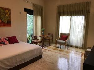 1 dormitorio con 1 cama, mesa y sillas en Real Escondida, en Playa del Carmen