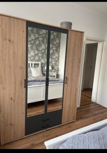 einen großen Holzschrank mit einem Bett in einem Schlafzimmer in der Unterkunft Ferienwohnung Ostfriesenherz Emden in Emden