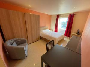 - une chambre avec un lit, une chaise et une table dans l'établissement Residence la Fraisiere, à Bruxelles