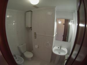 y baño con lavabo, aseo y espejo. en Habitaciones Trovador en Puerto de Sagunto