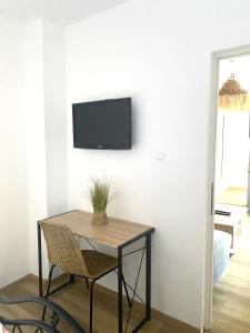 a room with a table and a tv on a wall at Boho Dream by Sandmar in Timişoara