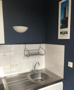 a kitchen with a sink and a blue wall at Sables d Or Studio 22 à 300 mètre de la plage in Frehel