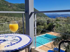 een glas wijn op een tafel naast een zwembad bij Villa Maya Lefkada in Évyiros