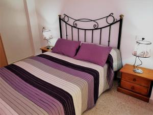 a bedroom with a large bed with purple pillows at Hostal Gutierrez in Ceuta