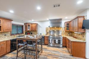 a kitchen with wooden cabinets and a wooden table at Spacious Home with Garden & Pool in Northridge