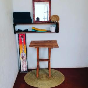 a small wooden table in a room with a mirror at Sonofjohnhomestay in Karatu