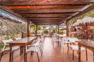 un ristorante con tavoli in legno e sedie bianche di Casa Giuliana a Charco del Pino