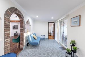 a living room with a blue couch and a brick wall at Spacious Home with Garden & Pool in Northridge