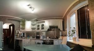 a kitchen with white cabinets and a table in it at Apartment on Novaya Street 5 in Bila Tserkva