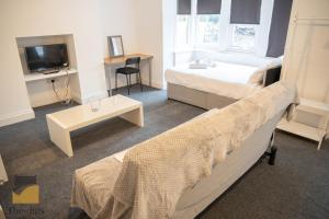 a bedroom with a bed and a tv and a couch at - Monthly Stay Offer - en-suite - kitchenette - in Monkwearmouth