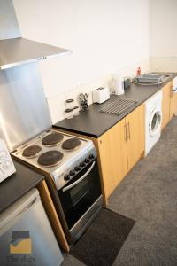 uma cozinha com um fogão e um lavatório em - Monthly Stay Offer - en-suite - kitchenette - em Monkwearmouth