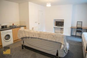 um quarto com uma cama e uma máquina de lavar roupa em - Monthly Stay Offer - en-suite - kitchenette - em Monkwearmouth