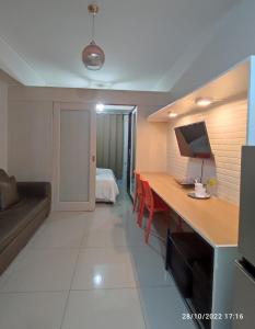 Zimmer mit einem Schreibtisch, einem Sofa und einem Schlafzimmer. in der Unterkunft Jazz Residences by Destina Stays, Makati, Metro Manila in Manila