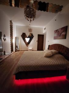 a bedroom with a large bed with a red light at Creekview Luxury Apartment in Ajman 