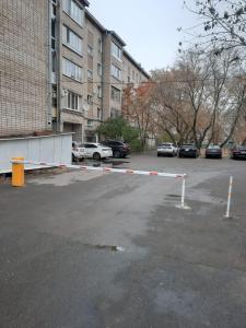 un estacionamiento con una barrera en un estacionamiento en Дизайнерская квартира в ста метрах от городского парка, en Petropavlovsk