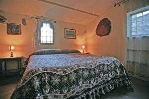 a bedroom with a bed with a black and white blanket at Agriturismo "Borgo Madonna degli Angeli" - charming cottages in the gardens ! in Tocco da Casauria