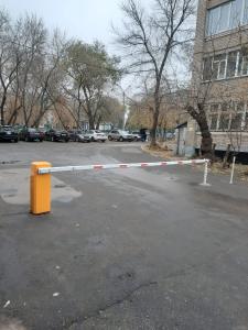 una barrera en un aparcamiento con coches aparcados en Квартира бизнес -класса в ста метрах от городского парка, en Petropavlovsk