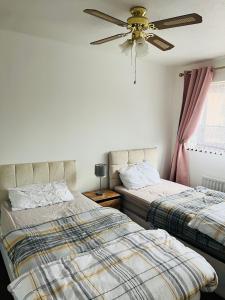 Bull, 3 bedroom House with Garden and Free Car Park في Stifford: غرفة نوم بسريرين ومروحة سقف