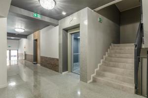 un couloir vide avec des escaliers dans un bâtiment dans l'établissement Modern Riverside Apartment with Free parking space, à Szczecin
