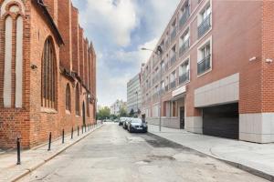 een straat met gebouwen en een auto op straat bij Modern Riverside Apartment with Free parking space in Szczecin