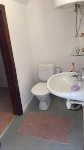 a bathroom with a white toilet and a sink at Całoroczny domek rustykalny in Siemiatycze