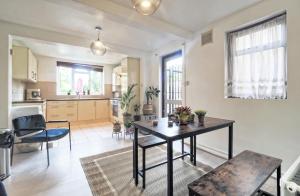 a living room with a table and a kitchen at Stunning, large 1 bed riverside flat in London