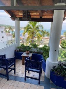 a balcony with two chairs and a table and a view of the ocean at Hotel & Hostal Mayflower in Puerto Escondido