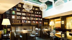 ein Restaurant mit Tischen, Stühlen und Bücherregalen in der Unterkunft Hotel Milano Scala in Mailand