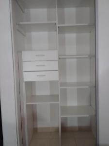 een kast met witte planken en witte kasten bij dpto centrico in Santa Fe