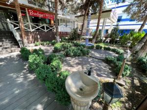 a fountain in a garden in front of a building at BUDGET HOTEL and HOSTEL in Tashkent