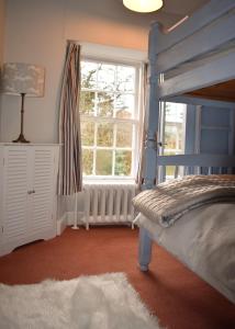 a bedroom with a blue bunk bed and a window at Creran Apartment, Kinlochlaich House in Appin