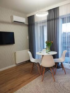 a dining room with a table and chairs and a television at Sleep in Plaza in Kielce