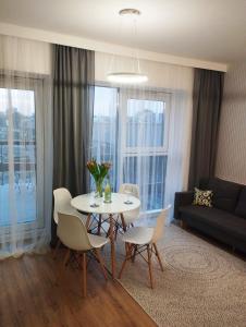 a living room with a table and chairs and a couch at Sleep in Plaza in Kielce