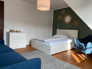 1 dormitorio con cama, silla y espejo en Ferienwohnung Brötzingen im 4. OG, en Pforzheim