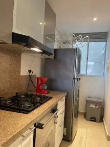 una cucina con piano cottura e frigorifero in acciaio inossidabile di Super Confort Santa Marta a Gaira