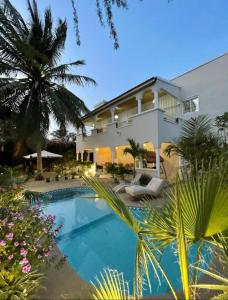 uma casa com uma piscina em frente em Villa Ngorè Saly em Saly Portudal