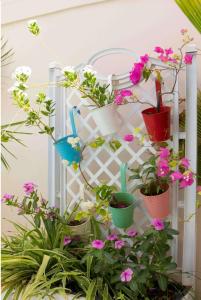 a white trellis with potted plants on it at Villa Ngorè Saly in Saly Portudal