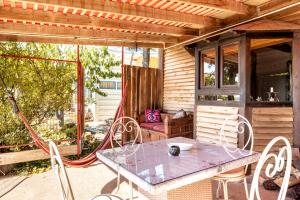 Un patio con una mesa y sillas en un porche. en Si-Har Chalets, en Nimrod