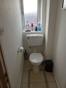 een kleine badkamer met een toilet en een raam bij Flat 4, Kingsbury house in Londen
