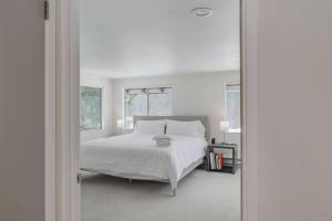 um quarto branco com uma cama e uma janela em Waterfront Cabin at White Pass and Mount Rainier National Park em Packwood