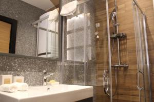 W łazience znajduje się umywalka i prysznic. w obiekcie Modern mountain - Crown apartment w mieście Kolašin