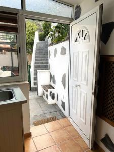 Une porte ouverte s'ouvre sur une cuisine dotée d'une terrasse. dans l'établissement Hibiscus Apartment, à Bajamar