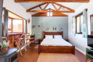 a bedroom with a wooden bed in a room with windows at Si-Har Chalets in Nimrod