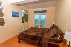 1 dormitorio con 1 cama y vistas al océano en Oceanfront 3-bedroom villa with spectacular view! en Calibishie