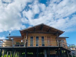 a log cabin with a blue sky and clouds at cabañas M&V in Quellón