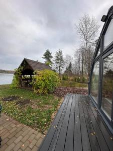 a wooden walkway next to a house with a building at Akmeni Nature Resort in Tome