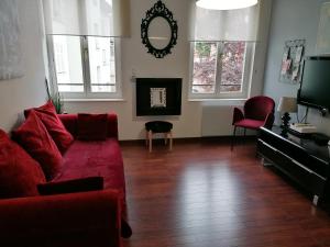 sala de estar con sofá rojo y TV en Appartement 3 pièces, Krutenau, Parking privé en Estrasburgo