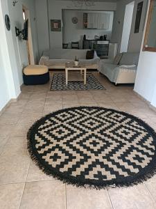 sala de estar con alfombra blanca y negra en el suelo en Apollon house, en Volos